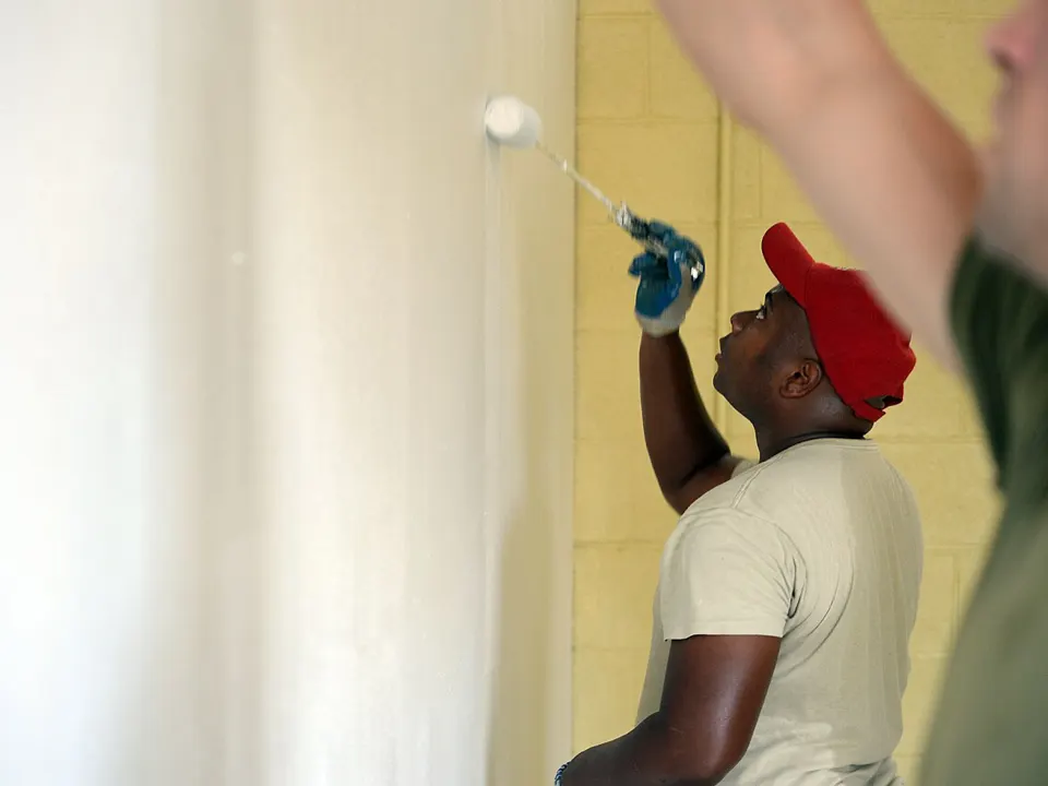 Worker rolling primer onto a repaired wall